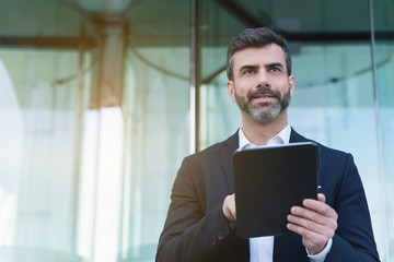 Empresario con tablet en distrito financiero