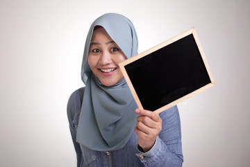 Smart Asian Muslim Woman  Smiling at Camera and Showing Empty Blackboard
