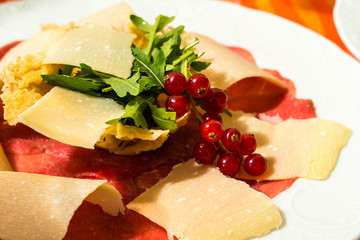 Rindfleisch Carpaccio mit Parmesankäse Späne Rucola und Preiselbeeren