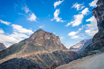 View of the dirt road between mountains on a cloudy day in Jebel Shams, Oman