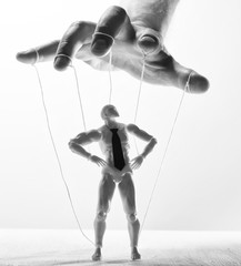 Concept of control. Marionette in human hand. Black and white image.