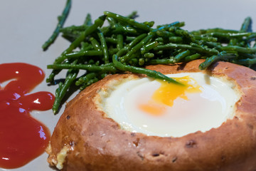 Healthy breakfast. Egg in bagel hole with samphire. Unusual meal.