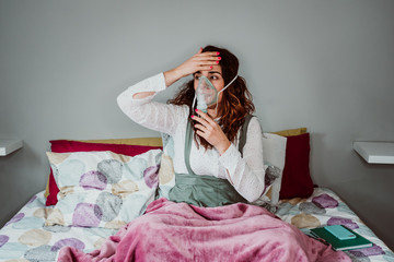 Young woman with weak health using assisted breathing at home. Treatment of a respiratory disease...