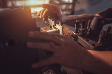 Close-up Worker handles metal at lathe Turner measures the dimensions of the metal workpiece with a caliper in uniform with safety. Work on a lathe.