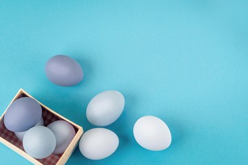lots of blue and light blue Easter eggs next to an open gift box, spring composition, flatlay copyspace
