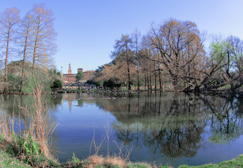 lake in the Sempione park with the Sforzesco castle surrounded by greenery