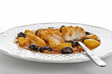 merluzzo al pomodoro con patate e olive nere fronte pezzi rotti con forchetta