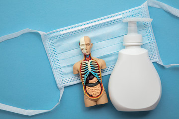 Protective medical mask and anti bacterial hand soap on a blue background