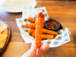 hand women take fried chicken stick with sauce
