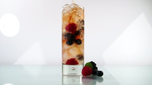 Pouring Berry Flavored Alcohol in a Glass on white Background