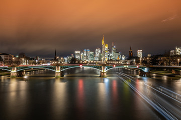 Fototapeta na wymiar Schiff fährt Richtung Frankfurter Skyline bei Sonnenuntergang