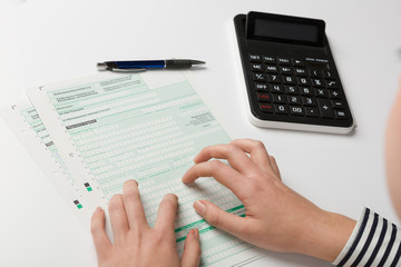 close up of forms for a tax declaration and stressed hands of a woman