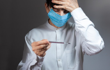 Coronavirus quarantine and Air pollution pm2.5 concept. Old sick woman wearing respirator mask for protect holds thermometer. Wuhan, China epidemic virus symptoms background.