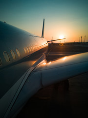 Fototapeta na wymiar Close up of Airplane with very soft orange sunset 