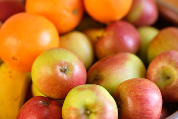 Still life with a heap of fresh and delicious apples and oranges lying in metal bow