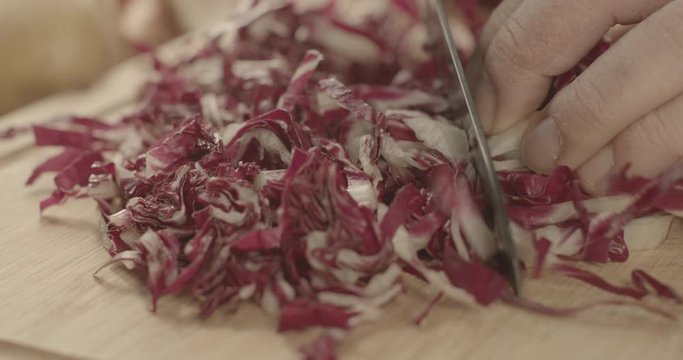 tagliare del radicchio su tagliere cucina italiana 