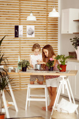 little girls transplanting indoor flowers into pot