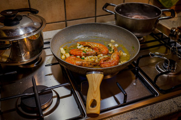 Cooking prawns on a pan lying on a stove.Concept: cuisine based on fish