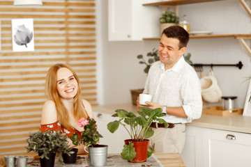 husband and wife in kitchen with potted flowers