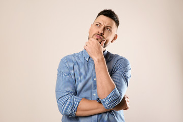 Emotional man in casual outfit on grey background