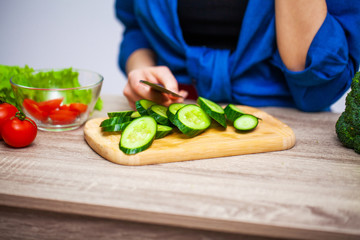 Concept of healthy eating, woman cuts fresh vegetables for salad