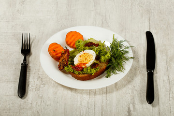 Fresh boiled egg with lettuce, parsley and dill. Healthy nutrition. Morning breakfast. Healthy organic natural food concept. View from above