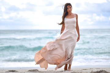 Girl in a fluttering dress on the beach