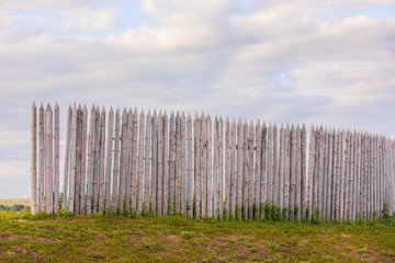 wood fence poles in green hill , rustic background