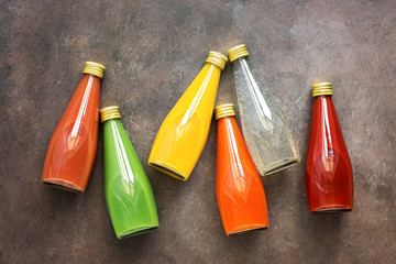 Assorted various colored juices in bottles on a dark background. Top view, flat lay. Juice - dragon...