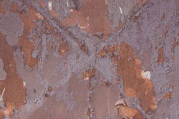 An old, rusty, colored plate with traces of background painting
