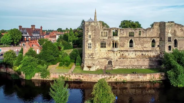 Ruins of medieval Gothic castle in Newark-on-Trent, near Nottingham, Nottinghamshire, England, UK. Aerial 4K video with Trent River in sunset light