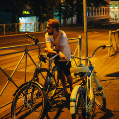 Man with cruiser bicycle in night city street