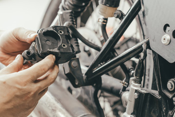Fototapeta na wymiar hand of mechanic man Replace and adjust motorcycle Rear Brake system