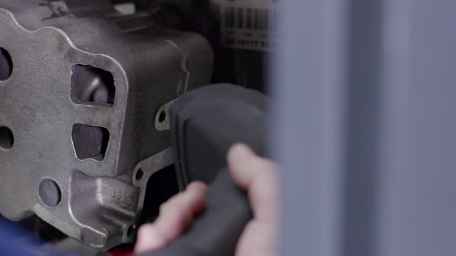 Quality control of part at automobile plant. Scene. Close-up scan of barcode on quality of car part at factory. Employee scans barcode on large automotive part