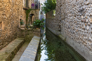 Fototapeta na wymiar View of the canal that crosses the historic center of St Llorenzo of La Muga.
