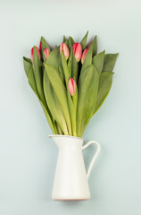 Fresh white tulip flowers bouquet in front of white brick wall.