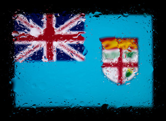 Flag of Fiji. Abstract photo with water drops on glass. Isolated on black background.