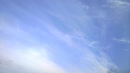 Blue sky with blurry white clouds. Shades of color. Tenderness, dreams and inspiration. Copy space. Beautiful abstract background. Fresh air concept. Environment. 