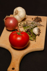 wooden cutting board close up and other spices focus on tomato 