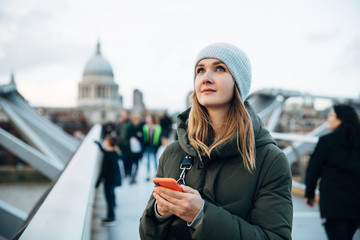 Portrait of young attractive stylish hipster woman wearing winter hat, coat and trendy leather...