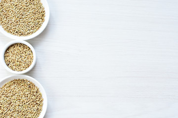 Seed of birdseed, food for birds, displayed in containers on white wooden background