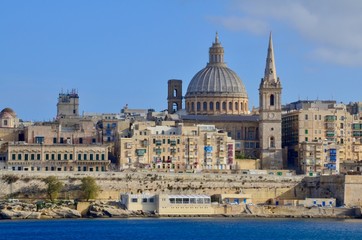 Fototapeta na wymiar The medieval limestone city of Valletta with its main symbols - bell tower of St Paul Pro-Cathedral and large dome of Carmelite church, Malta