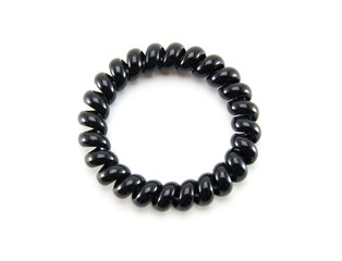 One black spiral elastic for hair on a white isolated background. A flexible plastic item for a female hairstyle or an arm bracelet. Elastic accessory