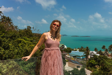 Fototapeta na wymiar A beautiful woman is relaxing in a rich villa with a pool with luxurious views of the sea and palm trees. Portraits of the face. Nice vacation. Exotic and tropics with a girl.