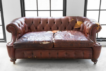 vintage style . Defective old leather sofa on white room
