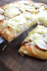 Tasty hot slice of pizza on a wooden board with melting cheese. Rustic pizza concept.