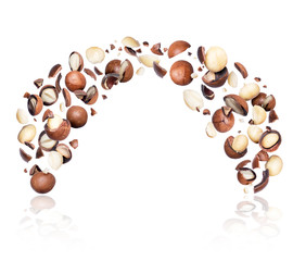 Macadamia nuts crushed in the air on a white background