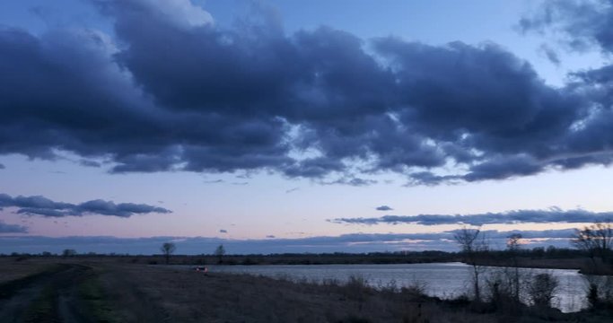 EC4 Evening Colorful  Cloudscape and Sunset above Field, Plains, Grove and River. Wind Blowing Dramatic Clouds. Rural Countryside Landscape. Season change Autumn, Winter, Spring