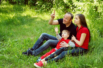 outdoor portrait of a happy family. Mom, dad and child looking up.