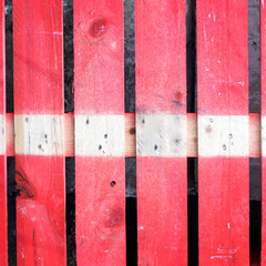 Fragment of red box of knocked-together boards and unevenly painted.